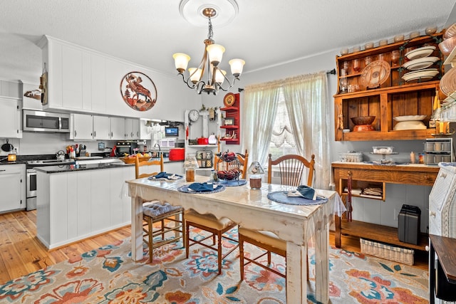 1005 S Main St, Mullins, SC 29574 - dining area featuring light wood-style floors, a chandelier, and a textured ceiling