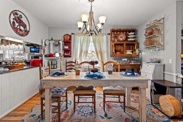 1005 S Main St, Mullins, SC 29574 - dining area with light wood-style floors, a chandelier, a textured ceiling, and crown molding