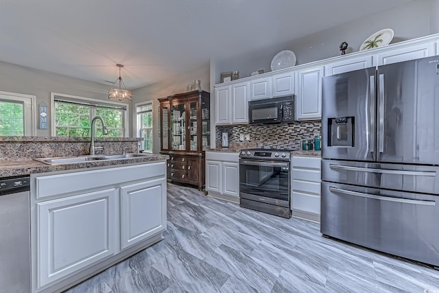 4355 Rivergate Ln Unit F, Little River, SC 29566 - kitchen featuring appliances with stainless steel finishes, white cabinetry, decorative backsplash, and pendant lighting
