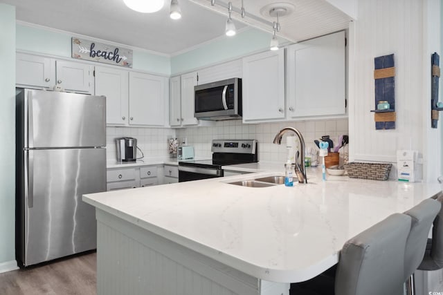 1011 S Ocean Blvd Unit 301, North Myrtle Beach, SC 29582 - kitchen featuring stainless steel appliances, a peninsula, tasteful backsplash, light stone counters, and crown molding