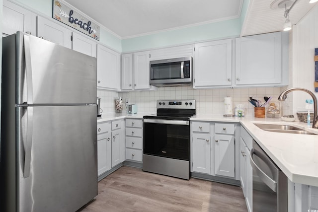 1011 S Ocean Blvd Unit 301, North Myrtle Beach, SC 29582 - kitchen with stainless steel appliances, crown molding, backsplash, light countertops, and light wood-type flooring