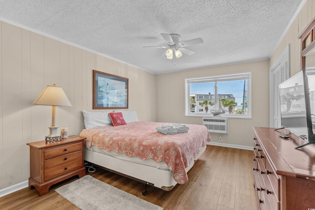 6301 N Ocean Blvd Unit 2B, North Myrtle Beach, SC 29582 - bedroom with wood finished floors, ornamental molding, a textured ceiling, a wall unit AC, and ceiling fan