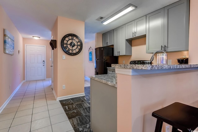 850 Fairway Dr Unit 904Ee, Longs, SC 29568 - kitchen with freestanding refrigerator, a peninsula, gray cabinetry, a kitchen breakfast bar, and light stone counters