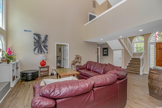189 Aspen Loop, Pawleys Island, SC 29585 - living room with stairway, light wood-style flooring, and a towering ceiling