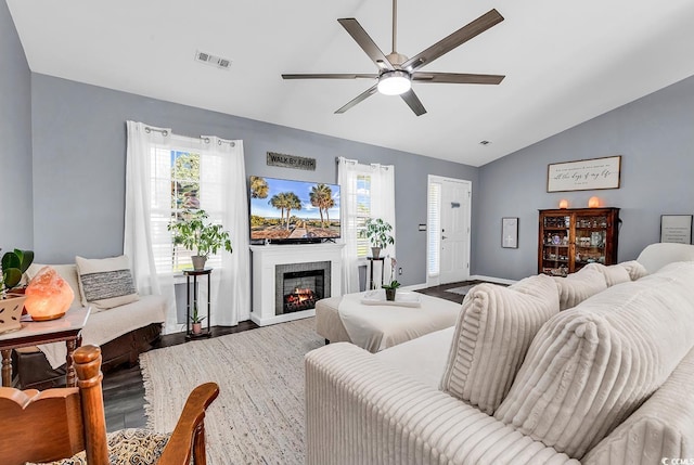 3907 Stillwood Dr, Myrtle Beach, SC 29588 - living area featuring lofted ceiling, a ceiling fan, plenty of natural light, wood finished floors, and a glass covered fireplace