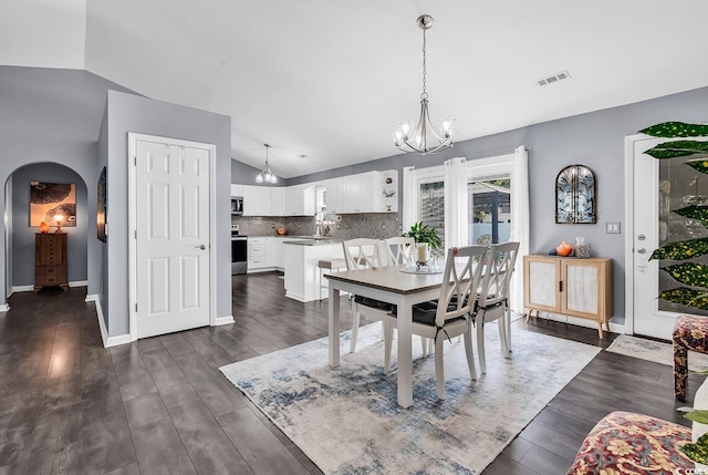 3907 Stillwood Dr, Myrtle Beach, SC 29588 - dining space featuring vaulted ceiling, arched walkways, dark wood-style floors, and a chandelier