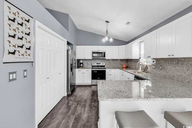 3907 Stillwood Dr, Myrtle Beach, SC 29588 - kitchen featuring stainless steel appliances, a peninsula, lofted ceiling, decorative backsplash, and light stone countertops