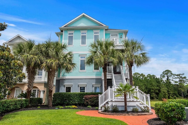 350 Saint Julian Ln, Myrtle Beach, SC 29579 - view of front of house featuring stairway, a front yard, stucco siding, a balcony, and a porch