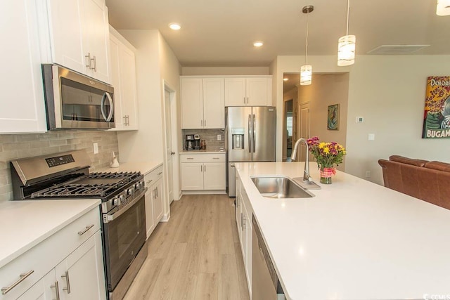 435 Rollins Dr, Longs, SC 29568 - kitchen featuring appliances with stainless steel finishes, light wood-style floors, tasteful backsplash, white cabinetry, and light countertops