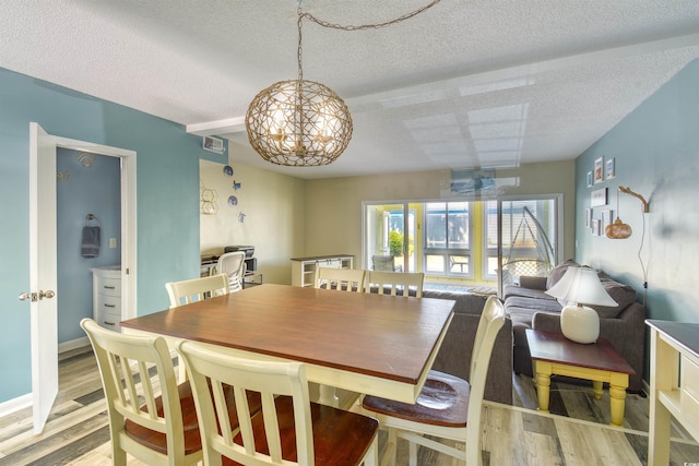 832 Villa Dr Unit 832, North Myrtle Beach, SC 29582 - dining area featuring a textured ceiling, light wood-style floors, and a chandelier
