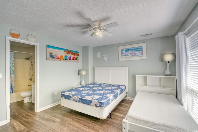 832 Villa Dr Unit 832, North Myrtle Beach, SC 29582 - bedroom featuring wood finished floors, a textured ceiling, ceiling fan, and ensuite bathroom
