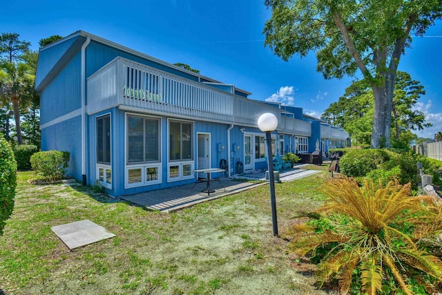 832 Villa Dr Unit 832, North Myrtle Beach, SC 29582 - back of house with a lawn, a patio area, and a balcony
