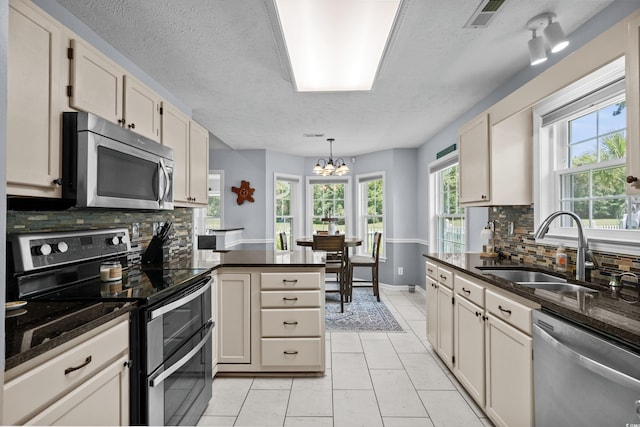 483 Oakmont Dr, Myrtle Beach, SC 29579 - kitchen featuring stainless steel appliances, tasteful backsplash, a chandelier, a peninsula, and light tile patterned floors