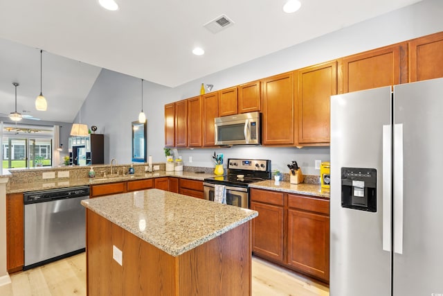 1590 Palmina Loop Unit A, Myrtle Beach, SC 29588 - kitchen with appliances with stainless steel finishes, light wood finished floors, lofted ceiling, light stone counters, and a center island