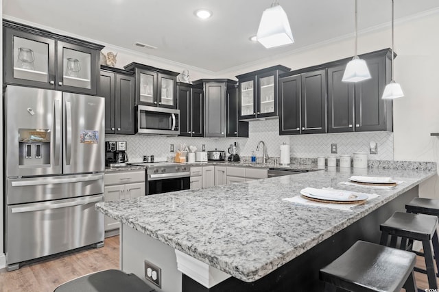 1428 Lanterns Rest Rd Unit 1428, Myrtle Beach, SC 29579 - kitchen featuring appliances with stainless steel finishes, a peninsula, a kitchen bar, light stone countertops, and ornamental molding