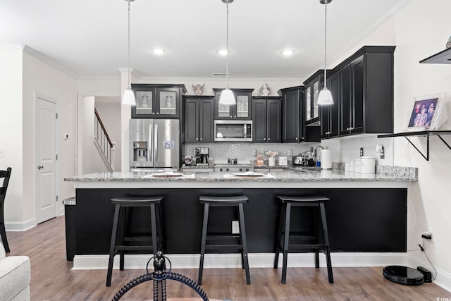 1428 Lanterns Rest Rd Unit 1428, Myrtle Beach, SC 29579 - kitchen with appliances with stainless steel finishes, dark cabinetry, a peninsula, glass insert cabinets, and decorative backsplash