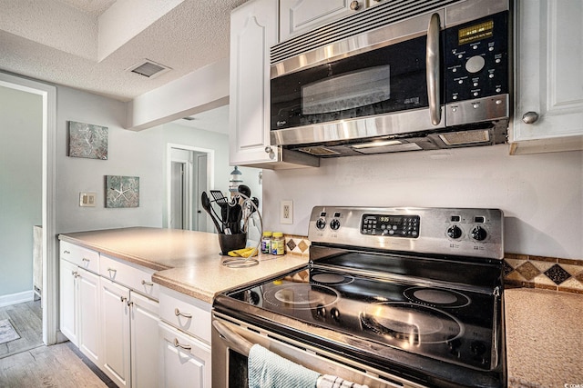 6570 Pebble Beach Cres, Myrtle Beach, SC 29588 - kitchen with appliances with stainless steel finishes, white cabinets, light countertops, and a textured ceiling