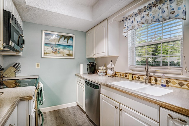 6570 Pebble Beach Cres, Myrtle Beach, SC 29588 - kitchen featuring stainless steel appliances, wood finished floors, white cabinets, tasteful backsplash, and light countertops