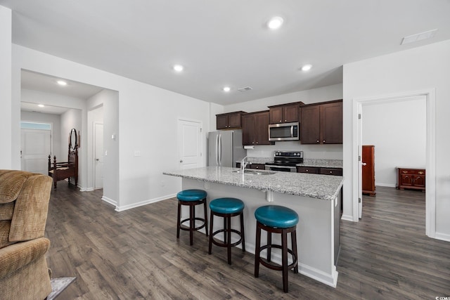 305 Forestbrook Cove Cir, Myrtle Beach, SC 29588 - kitchen featuring appliances with stainless steel finishes, a breakfast bar area, dark brown cabinets, a center island with sink, and dark wood-type flooring