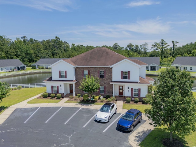 8855 Radcliff Dr NW Unit 50B, Calabash, NC 28467 - view of front facade with uncovered parking, a water view, brick siding, and view of wooded area