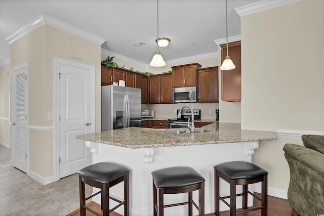 8855 Radcliff Dr NW Unit 50B, Calabash, NC 28467 - kitchen featuring stainless steel appliances, a peninsula, light stone countertops, a breakfast bar, and decorative backsplash