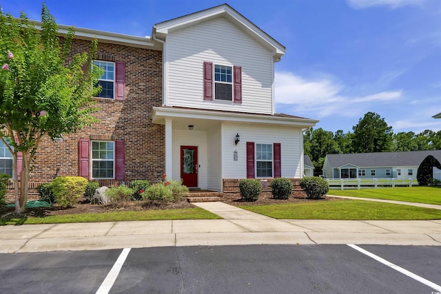 8855 Radcliff Dr NW Unit 50B, Calabash, NC 28467 - view of front of house featuring uncovered parking, brick siding, and a front yard