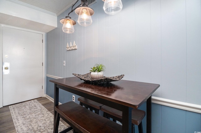 5601 N Ocean Blvd Unit E-113, Myrtle Beach, SC 29577 - dining space with dark wood finished floors, crown molding, and a decorative wall