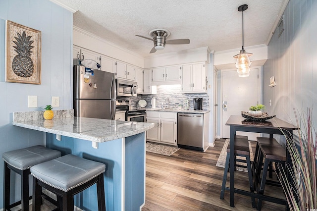 5601 N Ocean Blvd Unit E-113, Myrtle Beach, SC 29577 - kitchen featuring stainless steel appliances, a ceiling fan, a peninsula, wood finished floors, and a textured ceiling