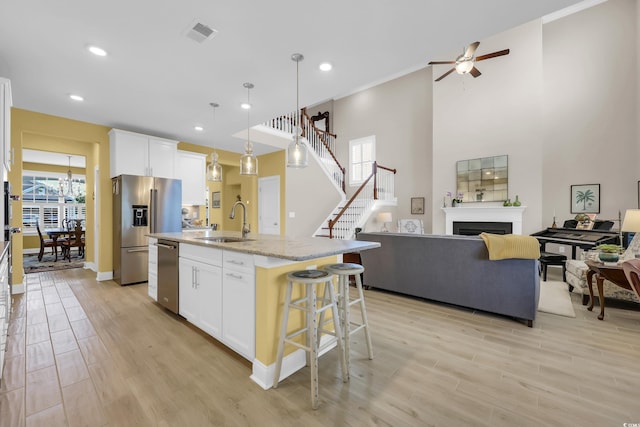 932 Abernathy Pl, Surfside Beach, SC 29575 - kitchen with stainless steel appliances, ceiling fan, open floor plan, a breakfast bar area, and light wood-style flooring