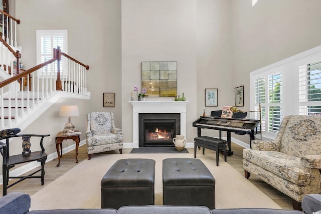 932 Abernathy Pl, Surfside Beach, SC 29575 - living room with a towering ceiling, wood finished floors, stairs, and a fireplace with flush hearth