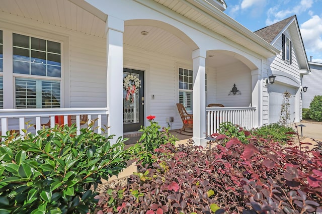 932 Abernathy Pl, Surfside Beach, SC 29575 - doorway to property featuring covered porch, a garage, and roof with shingles