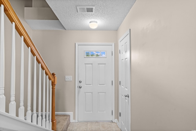 2131 Cass Lake Dr Unit 662, Carolina Shores, NC 28467 - foyer entrance featuring a textured ceiling, stairs, and light tile patterned floors