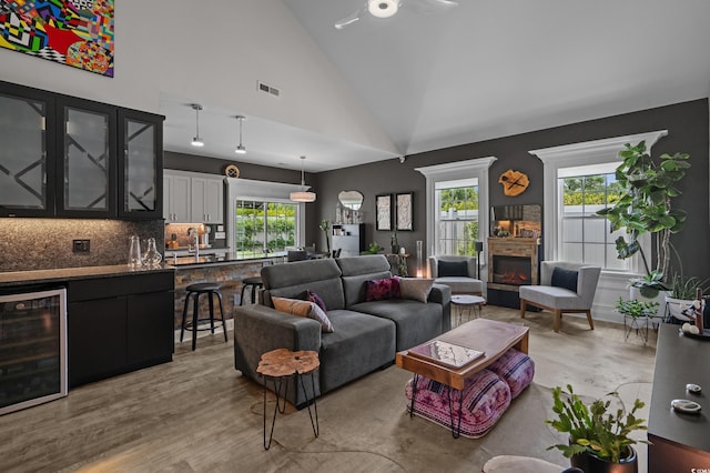 752 Hobonny Loop, Longs, SC 29568 - living area with wine cooler, plenty of natural light, a lit fireplace, a ceiling fan, and high vaulted ceiling