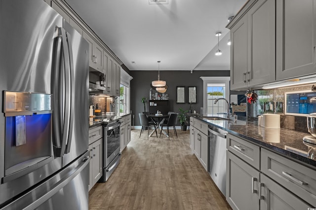 752 Hobonny Loop, Longs, SC 29568 - kitchen with appliances with stainless steel finishes, backsplash, gray cabinets, dark stone countertops, and wood finished floors