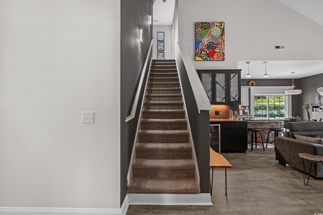 752 Hobonny Loop, Longs, SC 29568 - stairway with high vaulted ceiling, beverage cooler, and wood finished floors