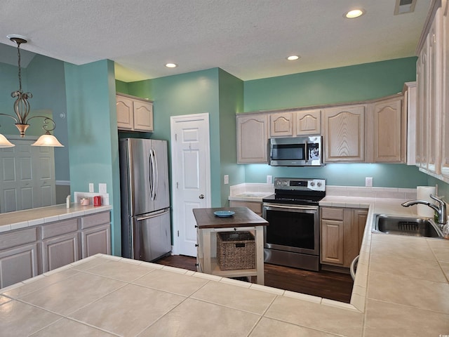 1028 Cherry Tree Ln, North Myrtle Beach, SC 29582 - kitchen featuring appliances with stainless steel finishes, tile countertops, recessed lighting, decorative light fixtures, and dark tile patterned flooring