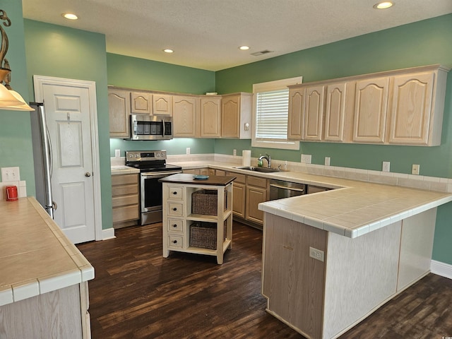 1028 Cherry Tree Ln, North Myrtle Beach, SC 29582 - kitchen with appliances with stainless steel finishes, light brown cabinetry, dark wood finished floors, a peninsula, and recessed lighting