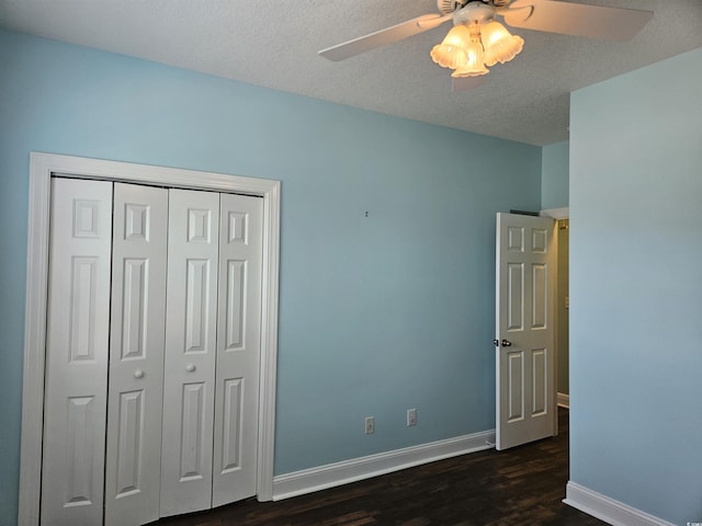 1028 Cherry Tree Ln, North Myrtle Beach, SC 29582 - unfurnished bedroom with dark wood-style flooring, a closet, a ceiling fan, and a textured ceiling