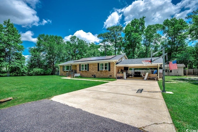 4189 Schoolhouse Cir, Little River, SC 29566 - view of front of home with concrete driveway, roof mounted solar panels, brick siding, crawl space, and a carport