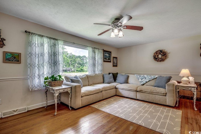 4189 Schoolhouse Cir, Little River, SC 29566 - living room with a ceiling fan, wood finished floors, and a textured ceiling