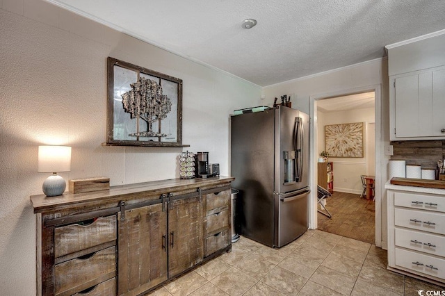 4189 Schoolhouse Cir, Little River, SC 29566 - kitchen featuring stainless steel refrigerator with ice dispenser, ornamental molding, white cabinets, and a textured ceiling