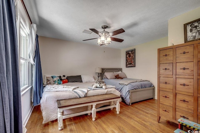 4189 Schoolhouse Cir, Little River, SC 29566 - bedroom featuring light wood finished floors, a textured ceiling, and a ceiling fan