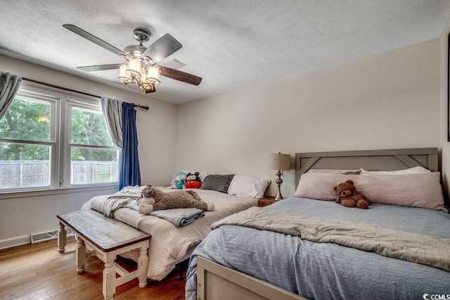4189 Schoolhouse Cir, Little River, SC 29566 - bedroom featuring wood finished floors, a textured ceiling, and a ceiling fan