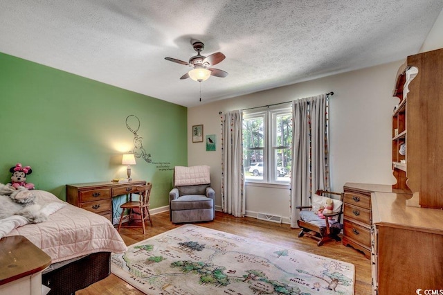 4189 Schoolhouse Cir, Little River, SC 29566 - bedroom with wood finished floors, ceiling fan, and a textured ceiling