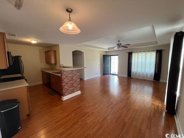 298 Weyburn St, Myrtle Beach, SC 29579 - kitchen featuring a raised ceiling, light countertops, wood finished floors, and open floor plan