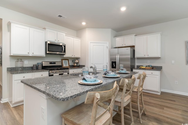 1402 Nokota Dr, Conway, SC 29526 - kitchen featuring appliances with stainless steel finishes, light wood finished floors, white cabinetry, a kitchen breakfast bar, and recessed lighting