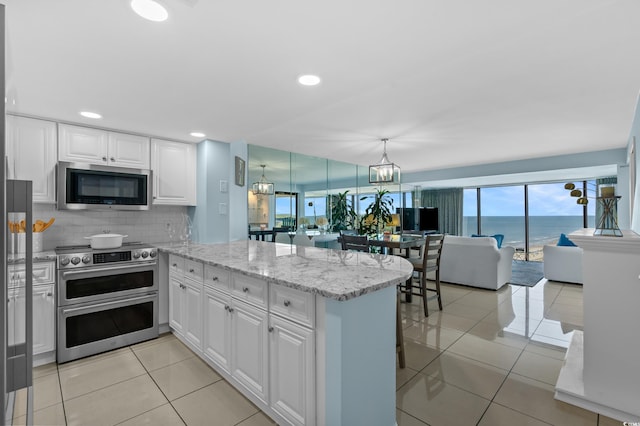 5511 N Ocean Blvd Unit 1801, Myrtle Beach, SC 29577 - kitchen featuring appliances with stainless steel finishes, a peninsula, white cabinetry, open floor plan, and light tile patterned floors