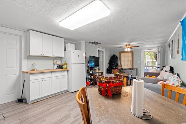304 1st Ave N, Myrtle Beach, SC 29577 - dining room featuring a textured ceiling, light wood-type flooring, and ceiling fan