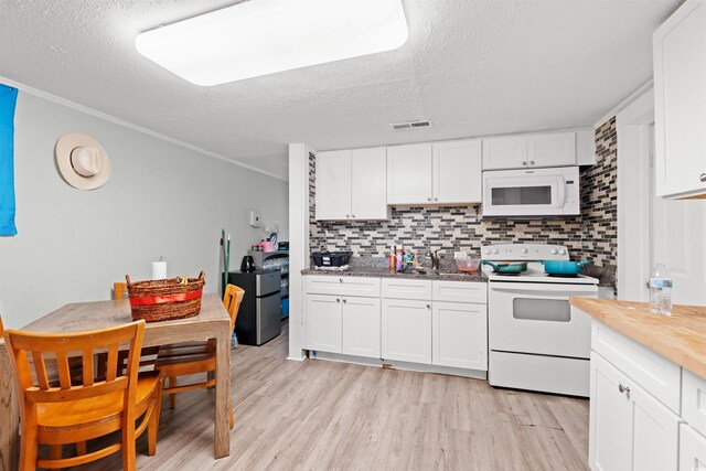 304 1st Ave N, Myrtle Beach, SC 29577 - kitchen with white appliances, a textured ceiling, backsplash, light wood-type flooring, and white cabinetry