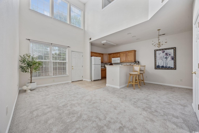 155 Chenoa Dr Unit E, Murrells Inlet, SC 29576 - living area featuring light carpet, a chandelier, and a high ceiling